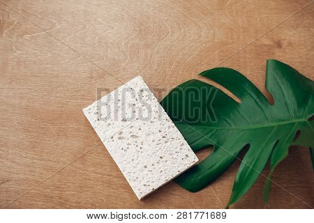 Reusable Natural Cellulose Sponge  On Wooden Background With Green Monstera Leaf. Zero Waste Concept