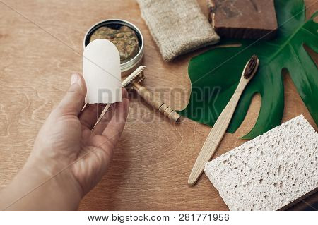 Hand Holding Natural Eco Crystal Deodorant On Background Of Bamboo Toothbrush, Soap, Solid Shampoo,