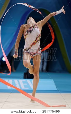 KIEV, UKRAINE - AUGUST 29, 2013: Lucille Chalopin, France performs with ribbon during 32nd Rhythmic Gymnastics World Championships. The event is held in Palace of Sport