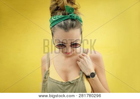 Portrait of stylish young woman outdoors on yellow background
