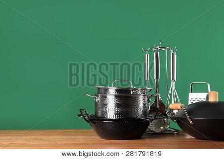 Set Of Clean Cookware And Utensils On Table Against Color Background. Space For Text