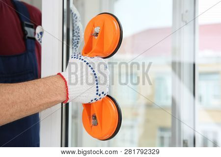 Construction Worker Using Suction Lifter During Window Installation Indoors, Closeup