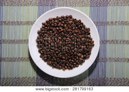 A Scattering Of Coffee Beans On A Plate. Bamboo Mat.
