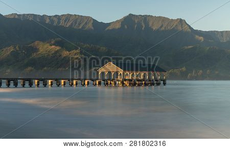 Sunrise Lights The Dawn Sky Above Hanalei Pier With The Na Pali Coast In The Background Near Hanalei