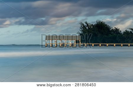 Sunrise Lights The Dawn Sky Above Hanalei Pier With Long Duration Exposure To Blur Waves Near Hanale