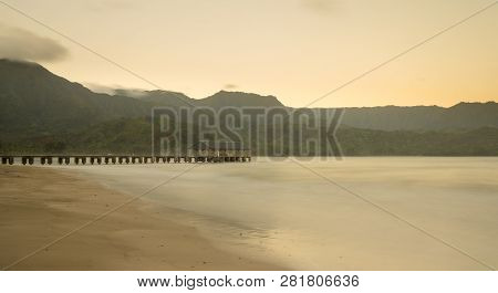 Sunrise Lights The Dawn Sky Above Hanalei Pier With The Na Pali Coast In The Background Near Hanalei