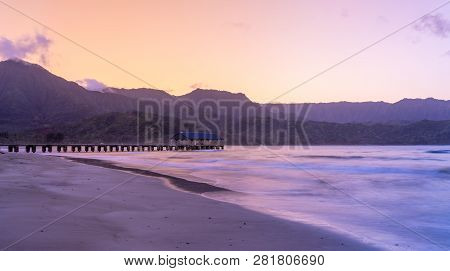 Sunrise Lights The Dawn Sky Above Hanalei Pier With The Na Pali Coast In The Background Near Hanalei