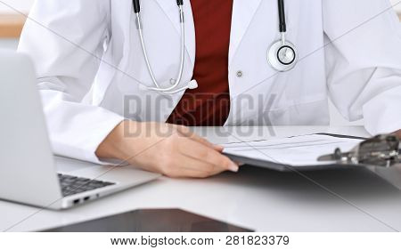 Close-up Of A Unknown Female Doctors Hands. Physician At Working Place Ready To Consult And Halp Pat