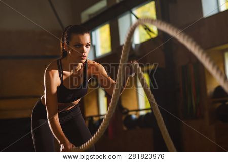 Fit, Sporty And Athletic Sportswoman Working In A Gym. Woman Training Using Battle Ropes. Sports, At