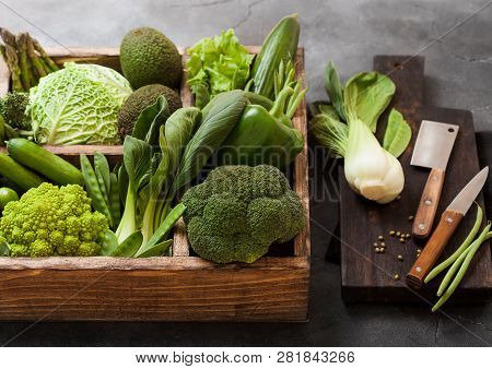 Assorted Green Toned Raw Organic Vegetables In Wooden Box On Dark Stone Background. Avocado, Cabbage