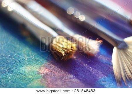 A Synthetic Brush, A Brush With Bristles And A Fan Brush Lie On The Palette, Painted With Different 