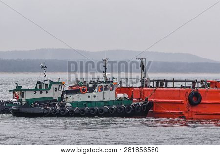Two Green Tugs - Small Ships Are Pushing A Barge On The Pomeranian Bay