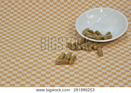 A Bunch Of Green Tea, On Leaf Capsules Or Pills On Dishes.