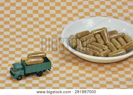 A Bunch Of Green Tea, On Leaf Capsules Or Pills. Truck Carrying Green Tea Capsules. Transportation O
