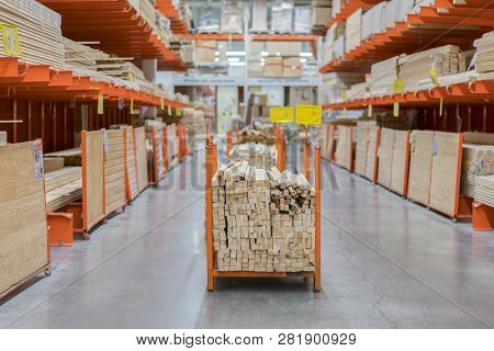 Stack New Wooden Bars On Shelves Inside Lumber Yard Of Large Hardware Store In America. Rack Of Fres