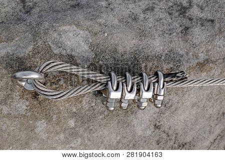 Stainless Twisted Rope Anchored In Rocky Wall. Stair Climbing And Iron Rope On Mountain Via Ferrata