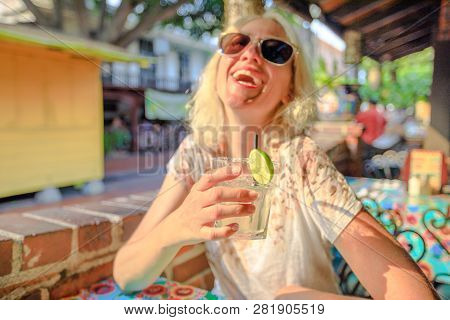 Glass Of Margarita, Mexican Cocktail Based On Tequila On Foreground. Smiling Caucasian Woman On Blur