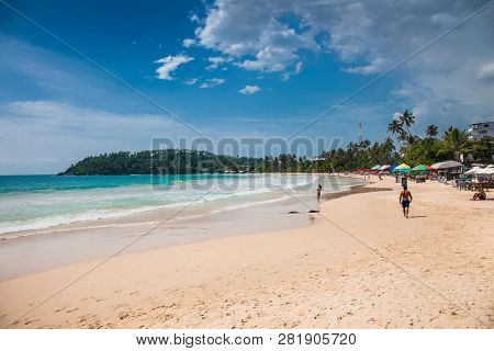 Mirissa Beach, Sri Lanka - JAN 2, 2017:  Tourists on the sand while enjoying the view across the wonderful beach of Mirissa on Jan 2, 2017. Sri Lanka.