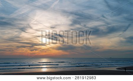 Carcavelos Beach, One Of The Most Famous Lisbon Beaches, At Sunset During Winter, With Many Surfers 