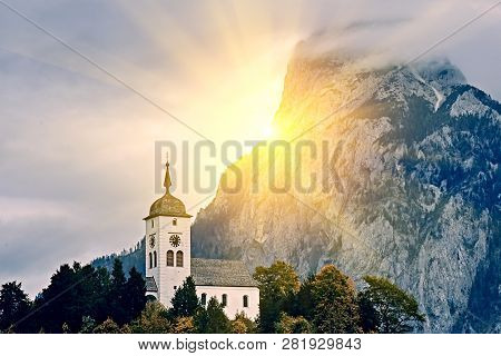Beautiful Scenic Sunset Over Austrian Alps Lake. Church On The Rock With Clouds Over Traunstein Moun