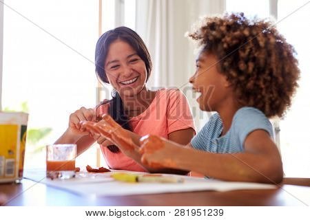 Close up of two girlfriends having fun playing with modelling clay at home, close up, selective focus