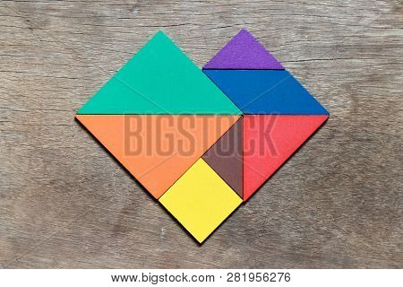 Color Tangram Puzzle In Heart Shape On Wood Background (concept For Lover Or Valentine 's Day)