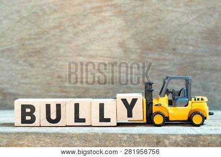 Toy Forklift Hold Letter Block Y To Complete Word Bully On Wood Background
