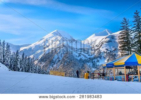 Bansko, Bulgaria - December 20, 2018: Ski Resort View With Ski Slope, People Skiing And Cafe