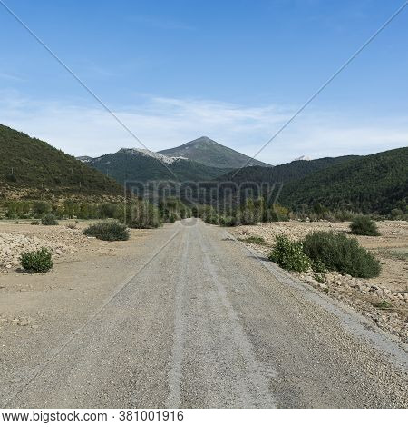 Stright Gravel Road Of Europe Peaks In Spain Early Morning. Beautiful Landscape With Dramatic View O