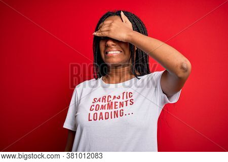 Young african american woman wearing sarcasm coments text on t-shirt over red background stressed with hand on head, shocked with shame and surprise face, angry and frustrated. Fear and upset 