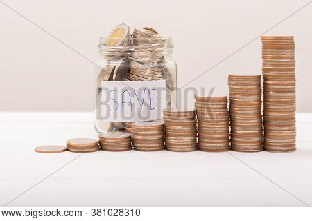 Hand Of Male Putting Coins In Jar With Money Stack Step Growing Growth Saving Money With Gray Backgr