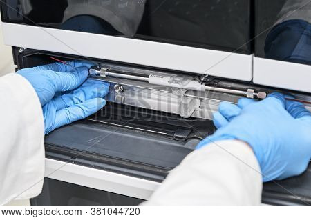 Chemist Or Scientist In Rubber Gloves Changing A Column On High Performance Liquid Chromatography Hp