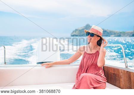 Woman In Hat And Dress Sailing On Boat In Clear Open Sea