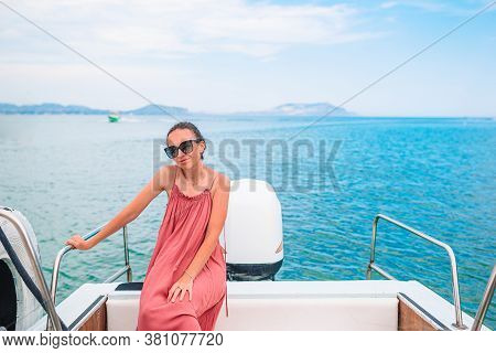 Woman In Hat And Dress Sailing On Boat In Clear Open Sea