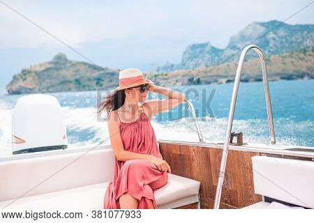 Woman In Hat And Dress Sailing On Boat In Clear Open Sea