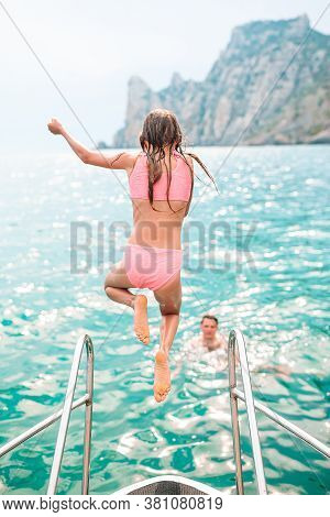 Little Girl Sailing On Boat In Clear Open Sea