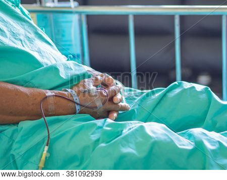 Close-up Of A Asian Senior Man Patient Is Receiving Blood Solution On Bed In The Hospital. Treatment