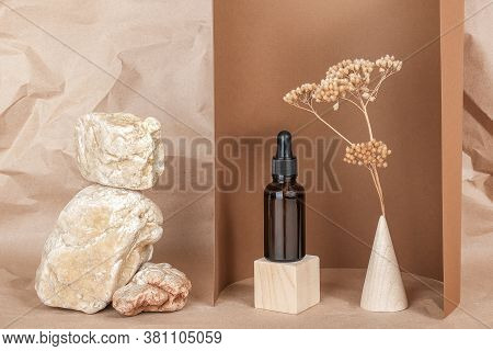 Serum, Essential Oils Or Fluid Collagen In Brown Glass Bottle With Pipette On Wooden Geometric Shape