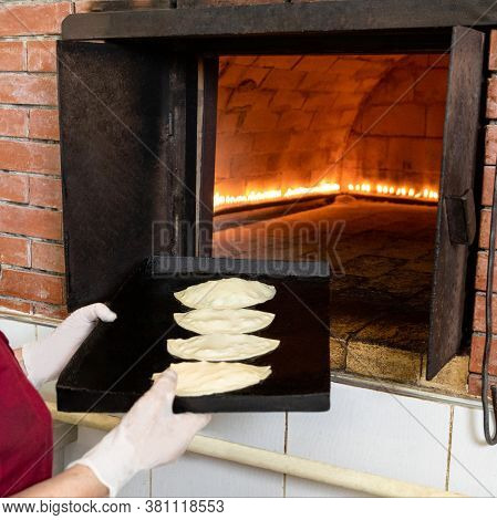 Woman Putting Qutab Meal To The Oven