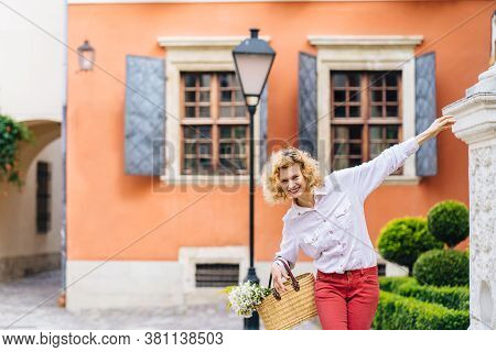 Portrait Of Romantic Mature Slim Blonde Woman In White Shirt Red Pants Enjoying, Walking Outdoor In 
