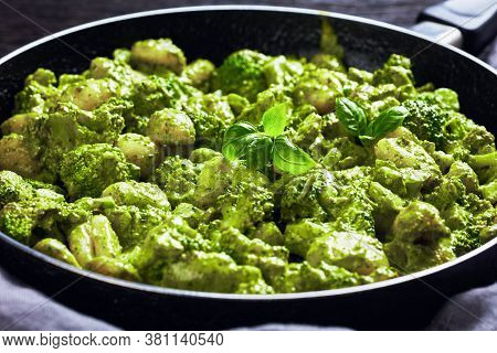 Italian Gnocchi With Broccoli Florets Tossed With Basil Pesto And Creamy Cheese Sauce In A Skillet, 