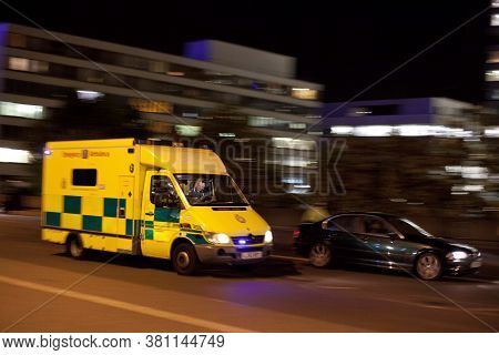 London Emergency Ambulance Responding At Night With Blue Lights And Motion Blur In London, England, 