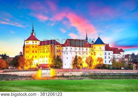 Fantastic Morning View Of Hartenfels Castle On Banks Of The Elbe. Dramatic Sunrise. Location: Torgau