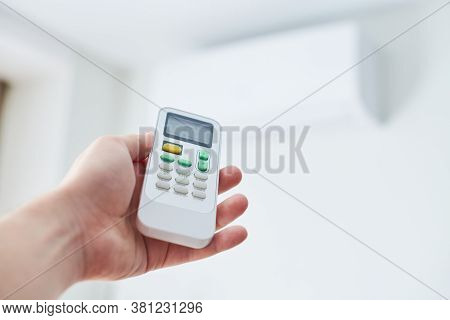 Air Condition Remote Control. Hand With Room Conditioner Remote Control. Air Temperature Switch For 