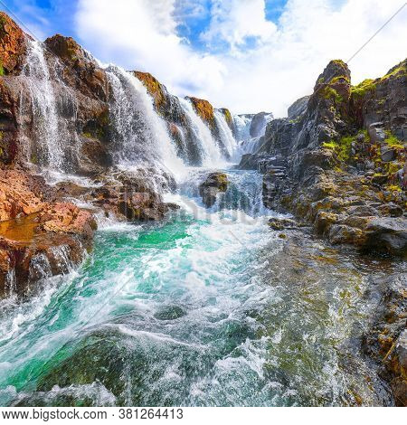 Charming View Of  Kolufossar Waterfall At Summer Sunny Day.  Popular Tourist Travel Destination In I