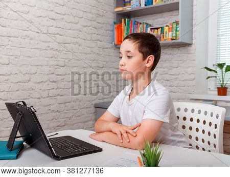 A Schoolboy Boy Studies At Home And Does School Homework. Home Distance Learning, Online Child Educa