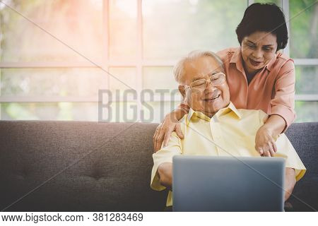 Happy Senior Couple Is Using Laptop For Technology Entertainment And Communication On Internet.