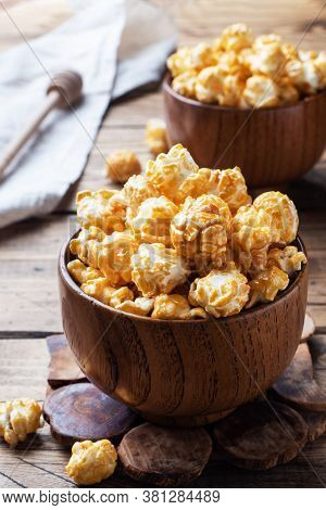Popcorn In Caramel Glaze In Wooden Plates On A Rustic Table.