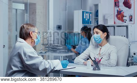 Woman Receiving Bad News At Doctor In Times Of Covid-19, Crying, Wearing Protective Mask, Talking Th