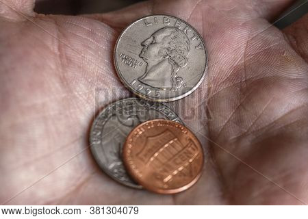 American Us Coins 1 And 15 Cents Lie On A Dirty Palm Close Up. An Impressive, Dramatic Shot With An 
